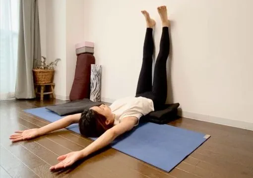 壁ピラティスをする女性